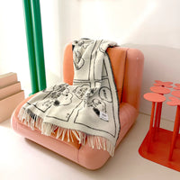Pink chair with a blanket draped over it in a room with colorful decor